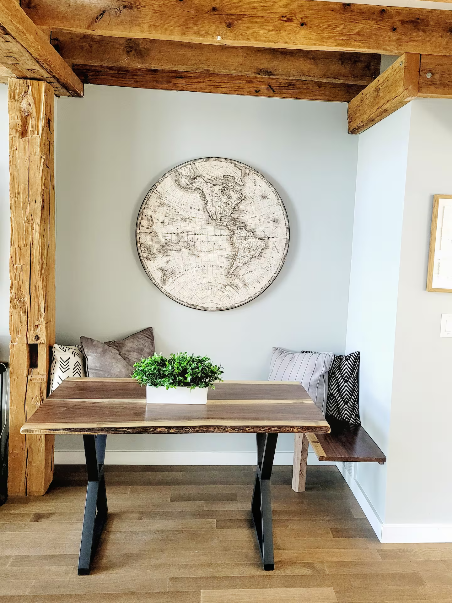 Live-edge dining nook beneath reclaimed wood beams